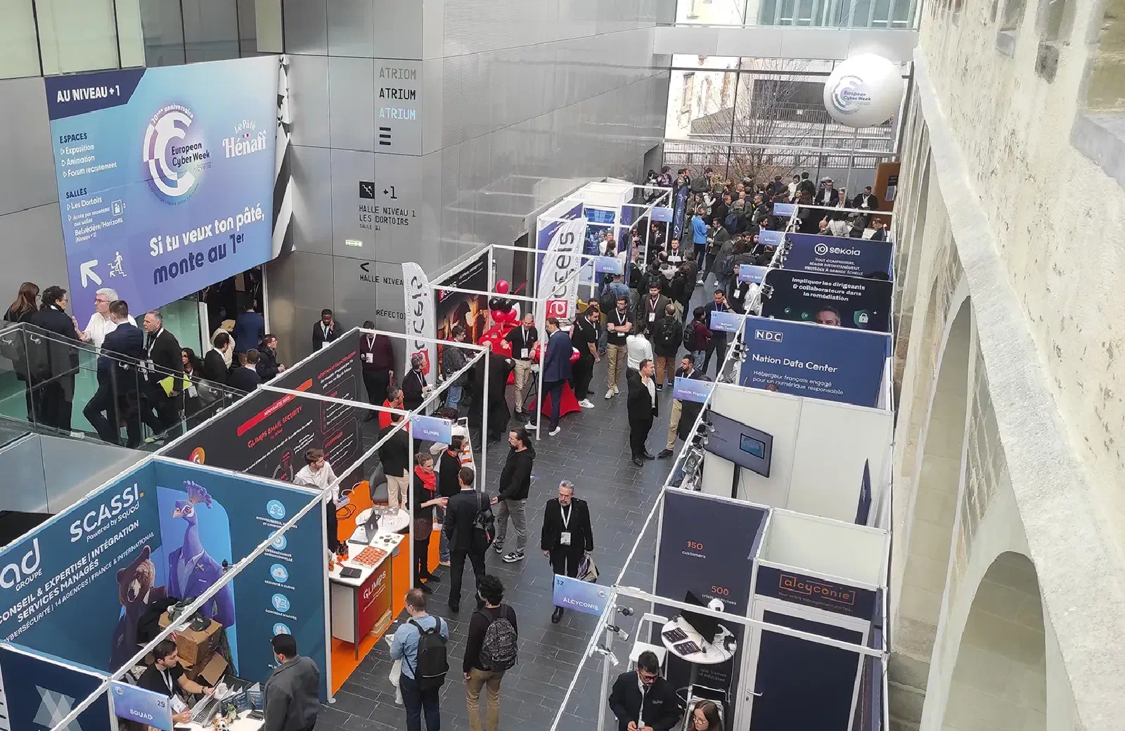 Allée des exposants de l'European Cyber Week au Couvent des Jacobins à Rennes, avec le stand ACCEIS et ses ballons rouges
